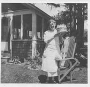 SA0061 - Alice Smith was from the Church Family. Outside unknown house with porch, lawn chair; cake with many candles.